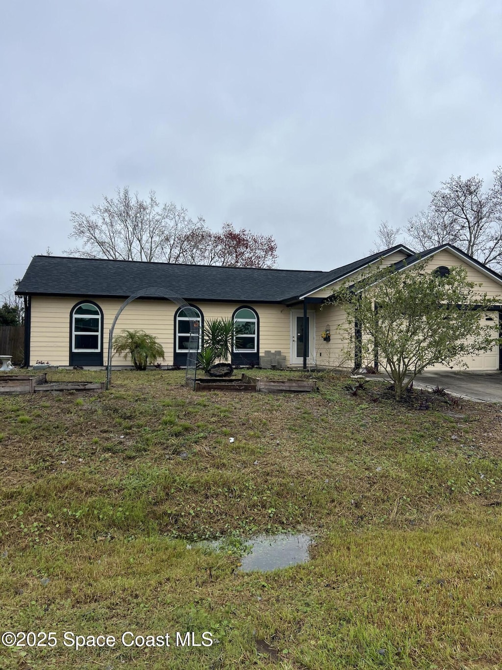 ranch-style home featuring a garage and a front lawn