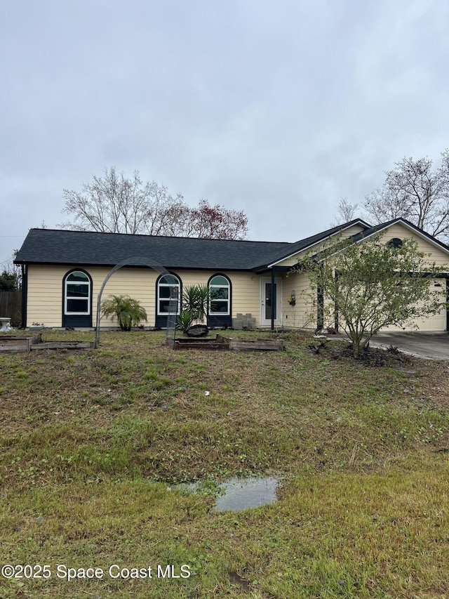 ranch-style home featuring a garage and a front lawn