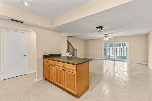 kitchen with ceiling fan, a textured ceiling, and light tile patterned flooring