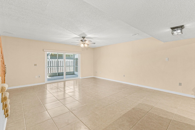 tiled spare room with a textured ceiling and ceiling fan