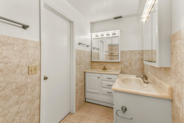 bathroom featuring tile patterned flooring, vanity, and tile walls