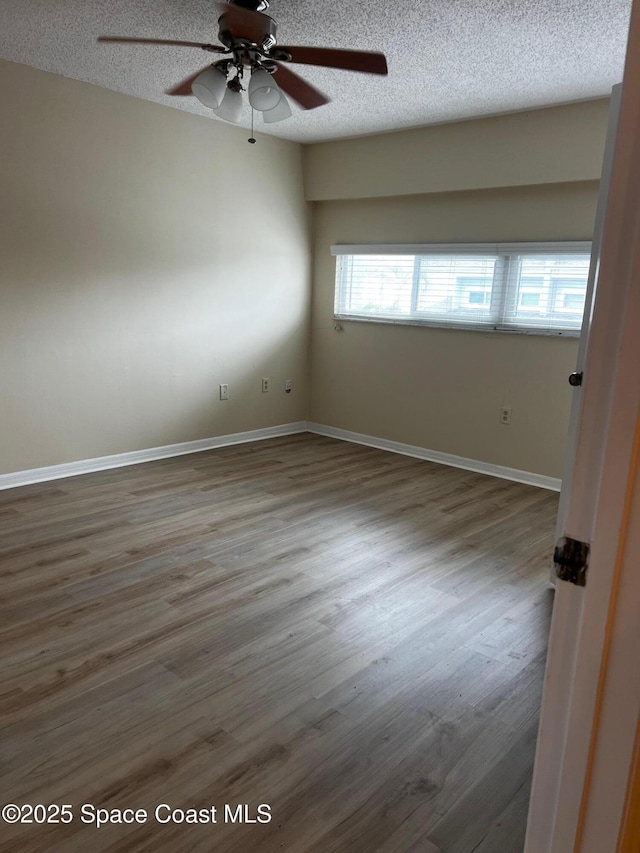 empty room with hardwood / wood-style flooring, a textured ceiling, and ceiling fan