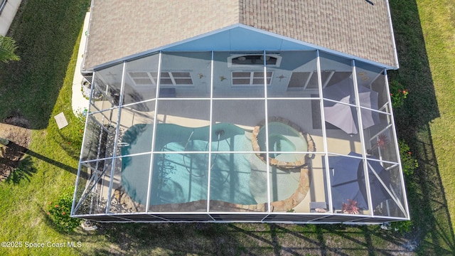 exterior space featuring glass enclosure and a swimming pool with hot tub