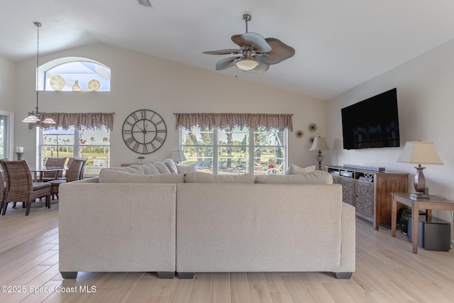 living room with light hardwood / wood-style floors, ceiling fan, and vaulted ceiling