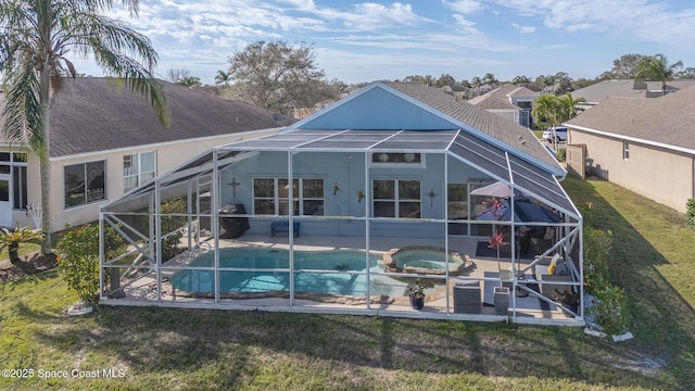 back of property with a patio area, a lanai, a yard, and a swimming pool with hot tub