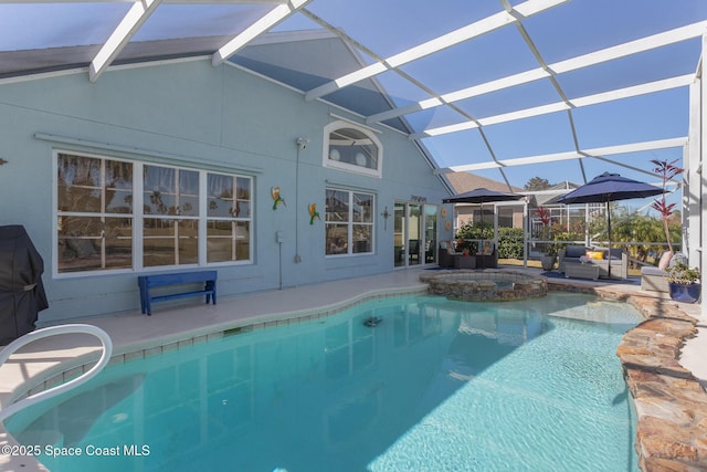 view of pool with a patio, glass enclosure, and an in ground hot tub