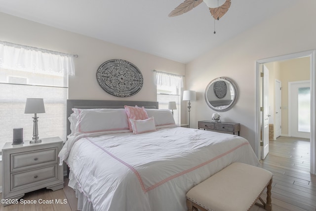 bedroom with vaulted ceiling, ceiling fan, and light hardwood / wood-style floors