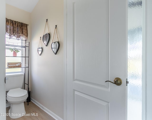 bathroom featuring hardwood / wood-style flooring, toilet, and a healthy amount of sunlight