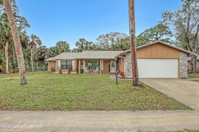 ranch-style house featuring covered porch, a front yard, and a garage