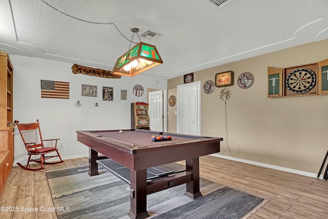 playroom featuring hardwood / wood-style floors, pool table, and a textured ceiling