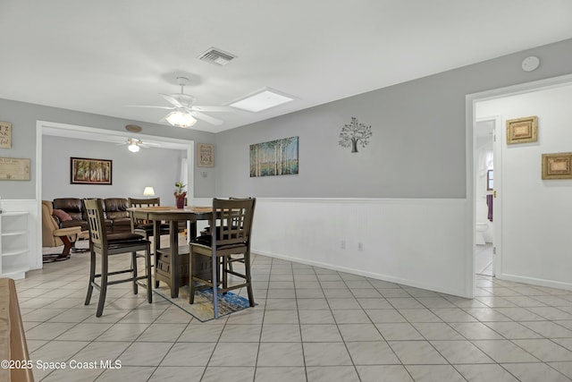 tiled dining space with ceiling fan