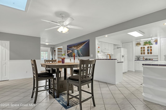 tiled dining space featuring ceiling fan