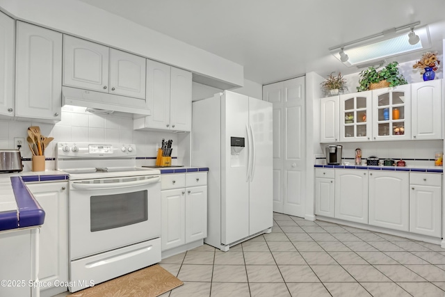 kitchen featuring white cabinets, white appliances, tasteful backsplash, and light tile patterned flooring