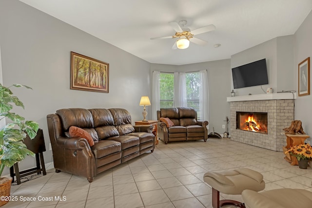 living room with a fireplace, light tile patterned flooring, and ceiling fan