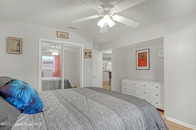 bedroom with a closet, ceiling fan, and light hardwood / wood-style flooring