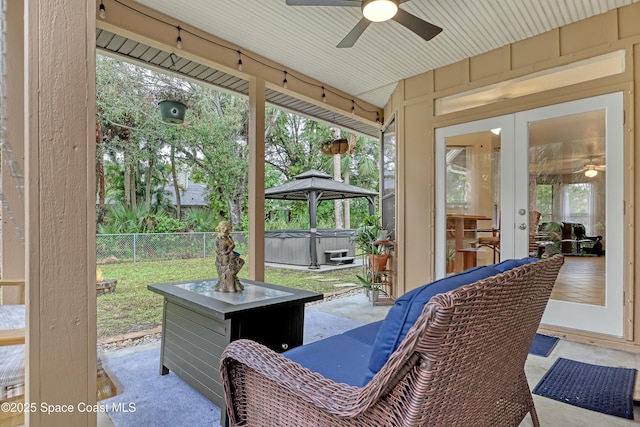 view of patio / terrace featuring ceiling fan, a hot tub, and french doors