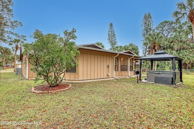 exterior space with a gazebo, a yard, and a hot tub