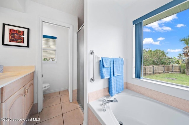 bathroom with toilet, plenty of natural light, tile patterned flooring, and a bath