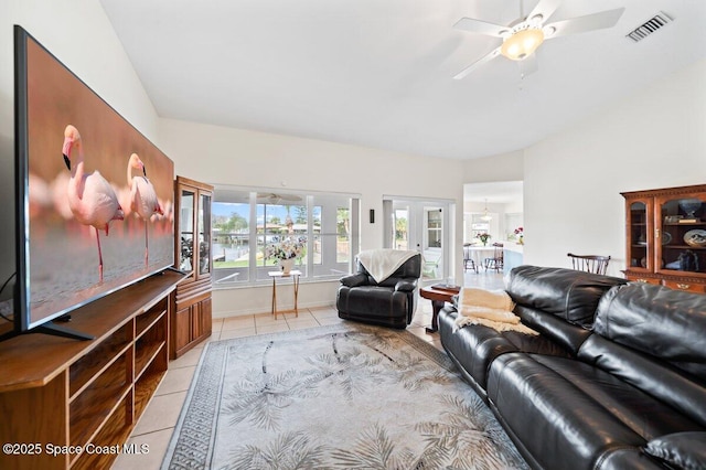 living room featuring light tile patterned floors, visible vents, ceiling fan, vaulted ceiling, and french doors