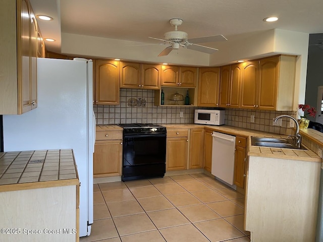 kitchen with white appliances, a sink, tile countertops, and decorative backsplash