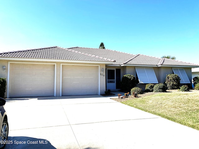 single story home with a front lawn, a tiled roof, stucco siding, driveway, and an attached garage