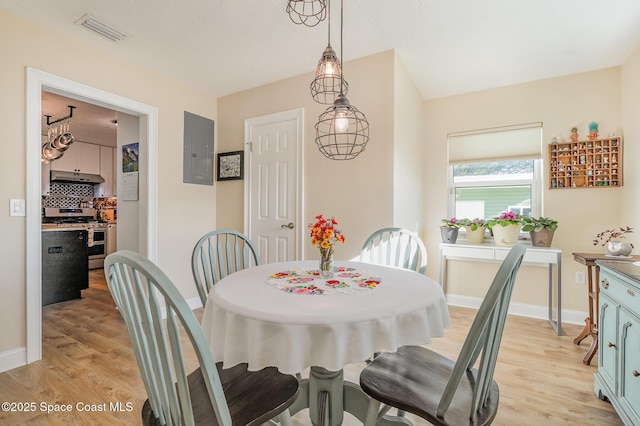 dining room with electric panel and light hardwood / wood-style floors