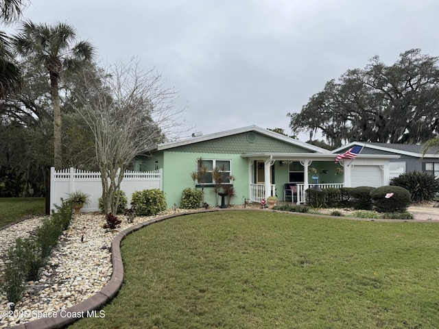 view of front of home with a garage, a porch, and a front lawn