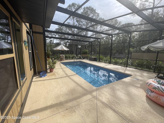 outdoor pool with a lanai and a patio area