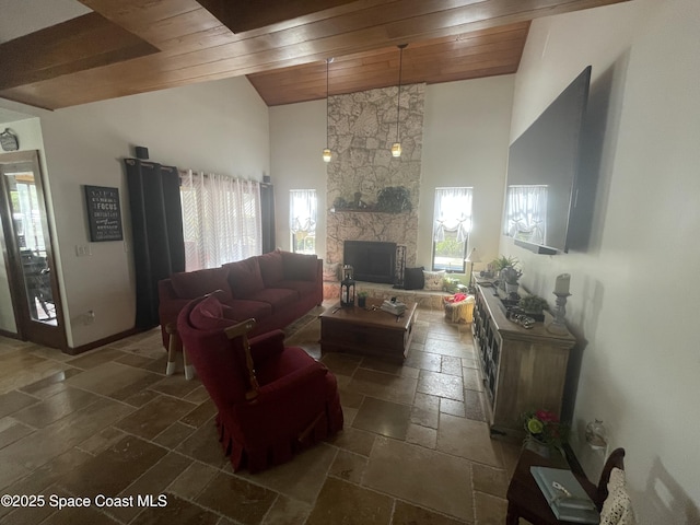 living room with wooden ceiling, high vaulted ceiling, stone tile flooring, and a stone fireplace