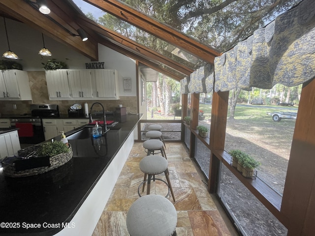 exterior space with vaulted ceiling with beams and a sink