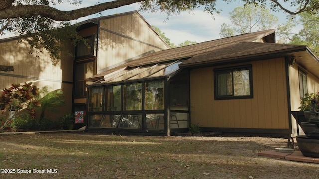 rear view of property with roof with shingles