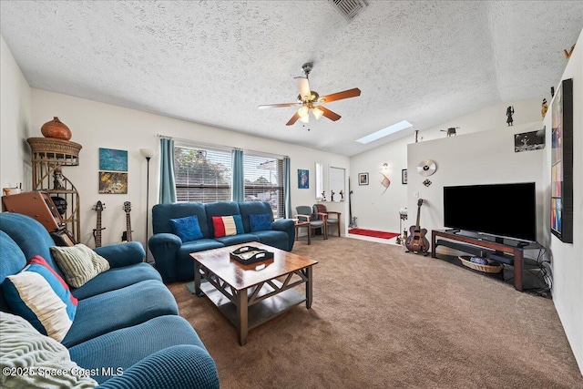 living room with ceiling fan, vaulted ceiling with skylight, dark carpet, and a textured ceiling