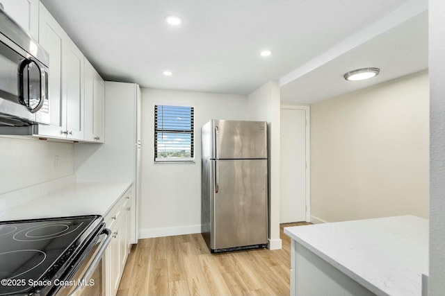 kitchen with light hardwood / wood-style floors, white cabinetry, and stainless steel appliances