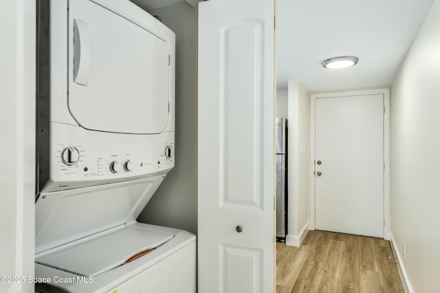 washroom featuring light hardwood / wood-style floors and stacked washer and dryer