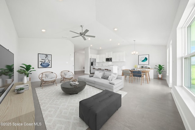 living room featuring sink, ceiling fan with notable chandelier, and lofted ceiling