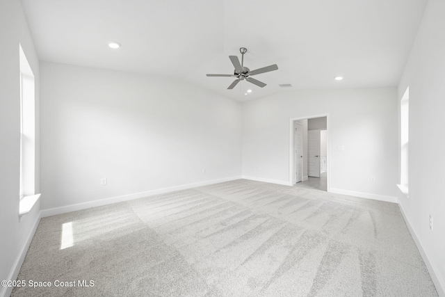 carpeted spare room featuring vaulted ceiling and ceiling fan