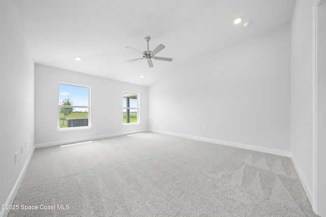 spare room with ceiling fan, light colored carpet, and lofted ceiling