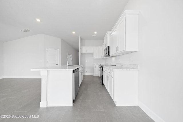 kitchen featuring appliances with stainless steel finishes, white cabinetry, an island with sink, sink, and light tile patterned flooring