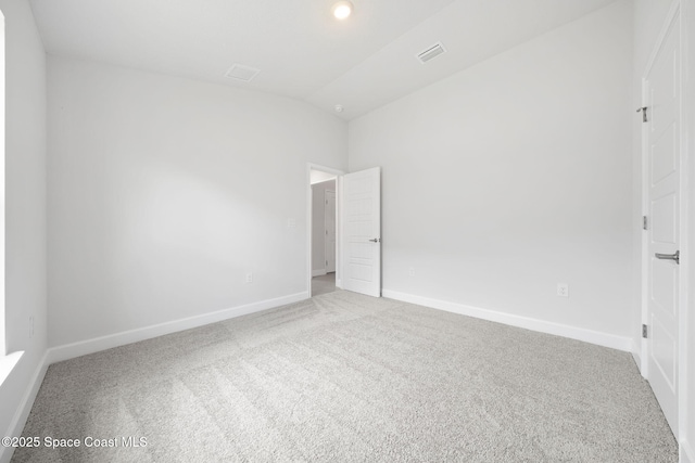 carpeted empty room featuring lofted ceiling