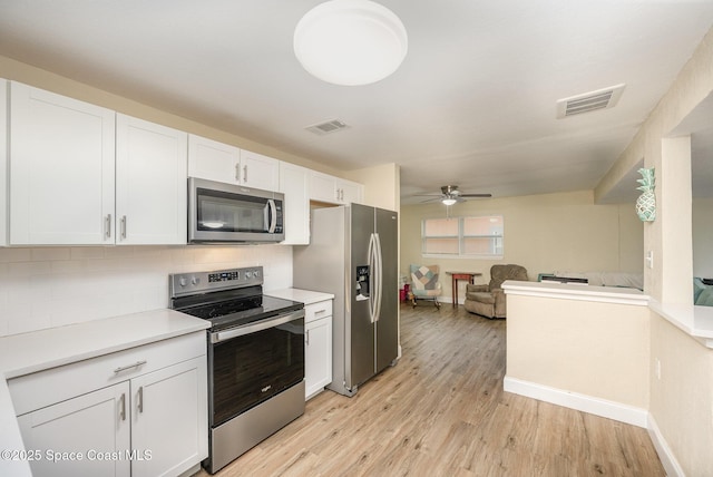 kitchen with white cabinets, backsplash, ceiling fan, stainless steel appliances, and light hardwood / wood-style flooring