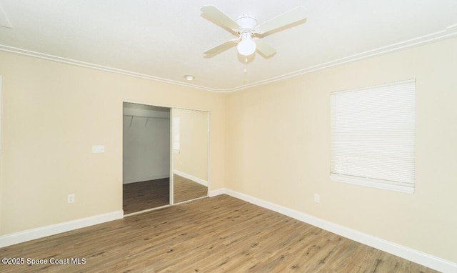 unfurnished bedroom featuring hardwood / wood-style floors, ornamental molding, a closet, and ceiling fan