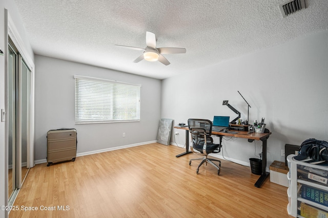 office with ceiling fan, a textured ceiling, and light wood-type flooring