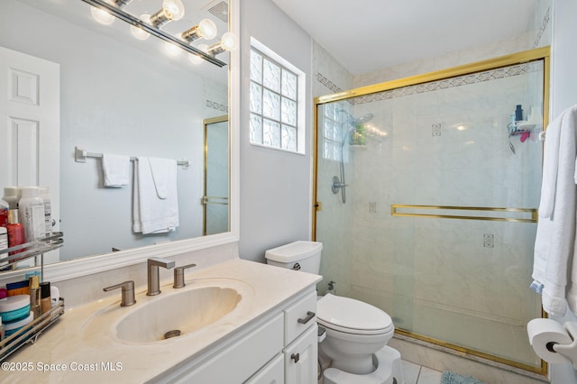 bathroom with vanity, toilet, tile patterned floors, and a shower with shower door