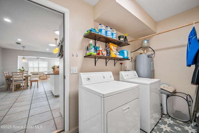 clothes washing area featuring water heater, light tile patterned flooring, ceiling fan, and washer and clothes dryer