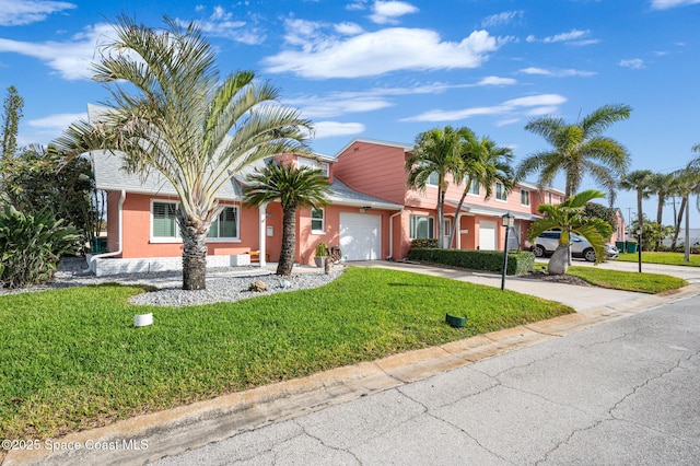 ranch-style home featuring a garage and a front lawn