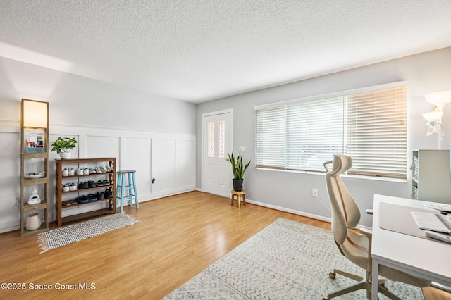 office with a textured ceiling and light hardwood / wood-style floors