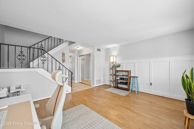 dining room featuring light hardwood / wood-style flooring and a textured ceiling