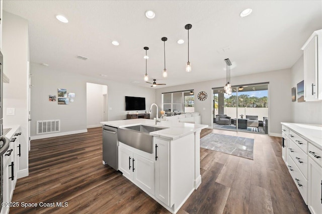 kitchen featuring sink, dishwasher, white cabinetry, and hanging light fixtures