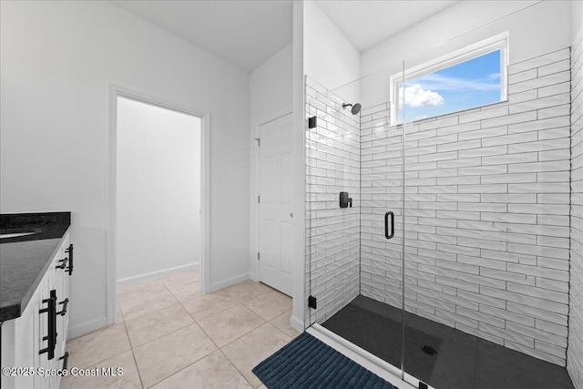 bathroom featuring tile patterned floors, a shower with door, and vanity