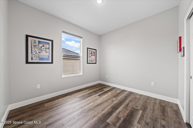 empty room with dark hardwood / wood-style flooring